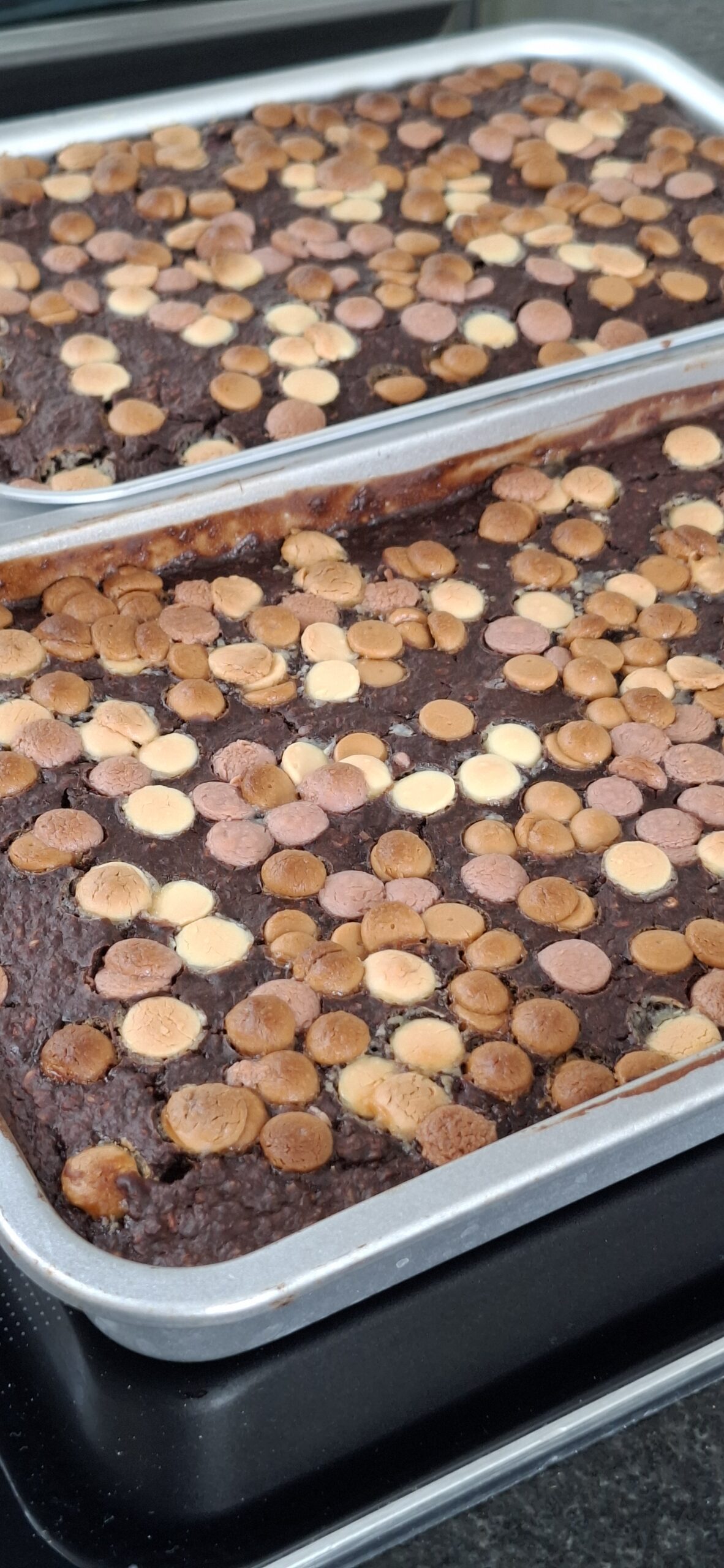 Saftige stykker af sund brownie med chokolade og lys chokoladetopping, serveret som mavevenlig snack.